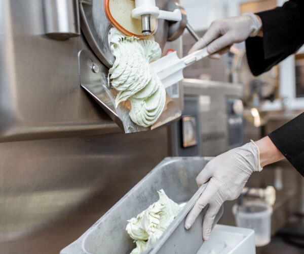 Pile of ready-made ice cream falling out of the freezer at the manufacturing, close-up